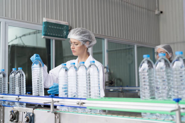 istock Female worker working inspecting quality clean purified drinking plastic bottled water inside automated conveyor belt production line in drinking water factory 2150507001