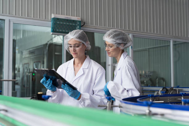 istock Two female worker working inspecting quality clean purified drinking plastic bottled water inside automated conveyor belt production line in drinking water factory 2150507012