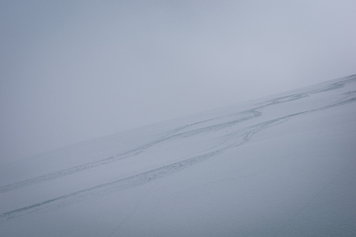 Ski tracks in fresh snow on mountain slope