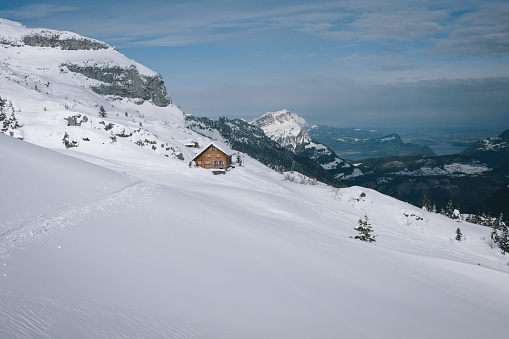 Mountain hut on snowcapped mountain and forest