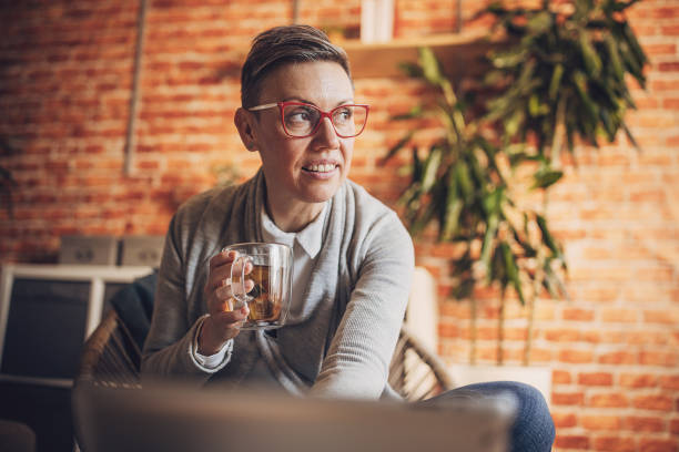 An image expressing contemplation as an individual holds a cup of tea, symbolizing a moment of peace and introspection in a comfortable, modern setting