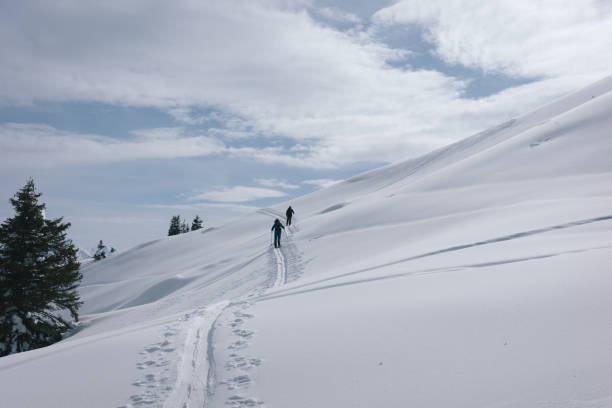 istock Backcountry skiers climb mountain 2150510104