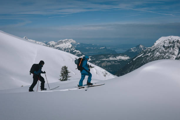 istock Backcountry skiers climb mountain 2150510135