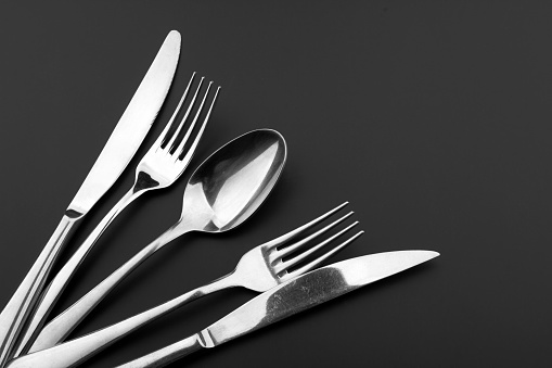Fork knife and spoon on black background