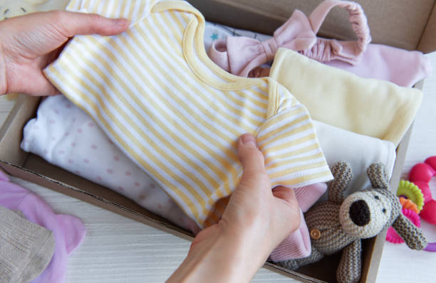 istock Women's hands collect children's clothes into boxes. 2150511526