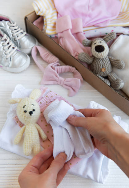 istock Women's hands collect children's clothes into boxes. 2150511527