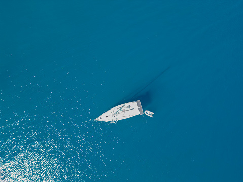 Aerial view of beautiful yacht on the sea in summer in Datca, Turkiye. Top view of luxury yacht, clear blue water, Travel concept.