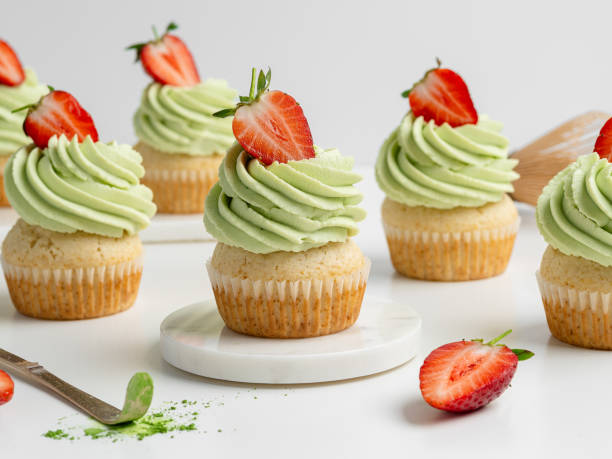 istock Matcha and lime cupcakes decorated with fresh strawberry slices. White background, closeup view. 2150511894
