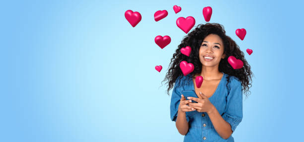 istock Smiling african woman with smartphone and heart falling, copy space 2150513077