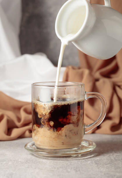 istock Pouring creme in a cup of coffee. 2150513240