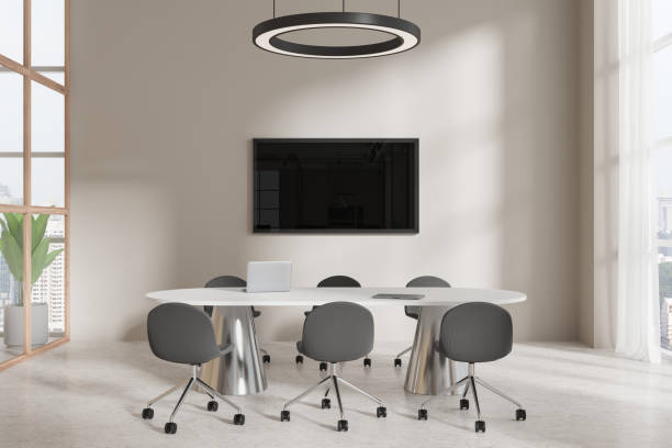 istock Cozy conference interior with table and armchairs, tv screen and window 2150513799
