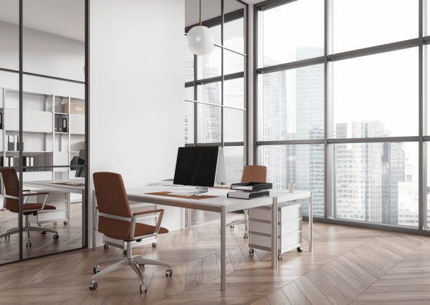 istock Stylish office interior with pc monitors on table and shelf, panoramic window 2150513853