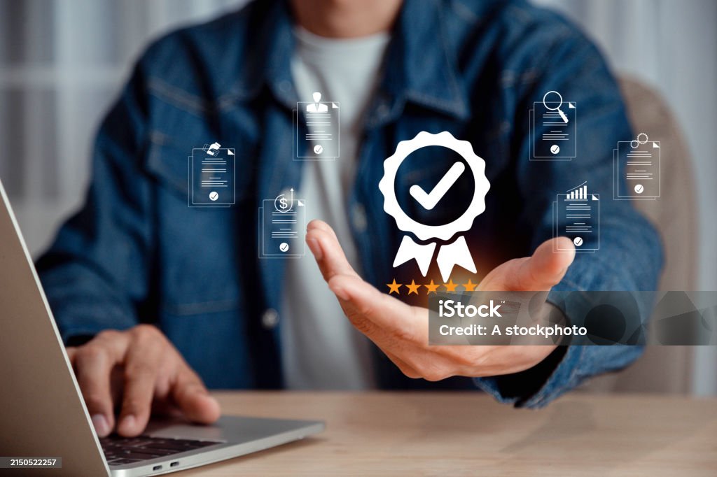 Бизнесмен держит и демонстрирует лучшую гарантию качества с пятью звездами, сертификацию и стандартизацию ISO, гарантию, стандарты, гарантию на продукцию и услуги, концепцию гарантии качества. Качество Фото со стока
