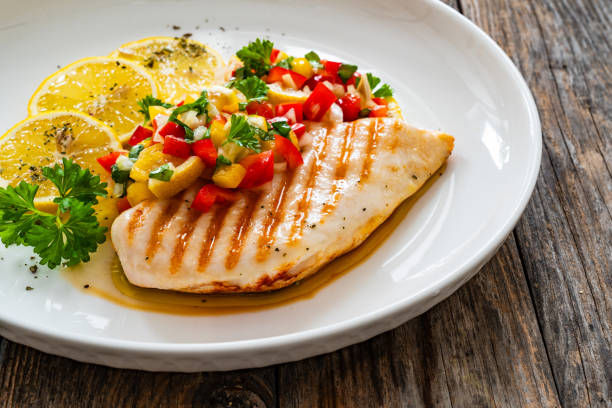 istock Grilled chicken breast and fresh vegetables on wooden table 2150522287