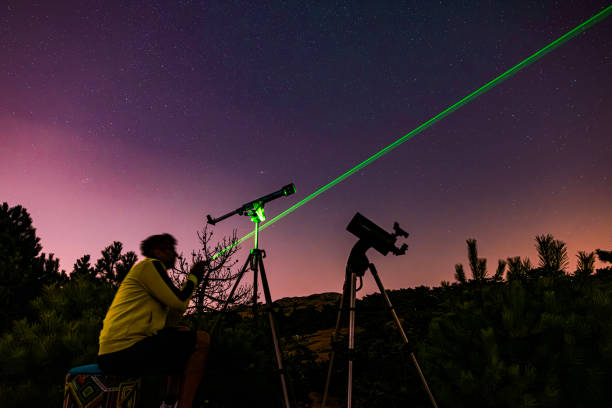 Astronomer looking at the starry skies with a telescope