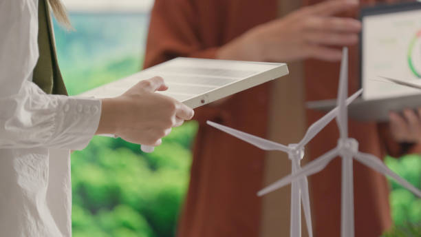 istock Hands Holding Solar Panel Model in Sustainable Energy Meeting. 2150523315