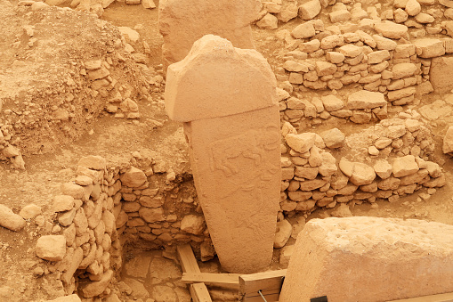 Pillar 2 in Enclosure A at the neolithic archaeological site of Göbekli Tepe, Potbelly Hill, a t-shaped pillar showing an auroch, a fox and a crane, close to Sanliurfa, Turkey 2022