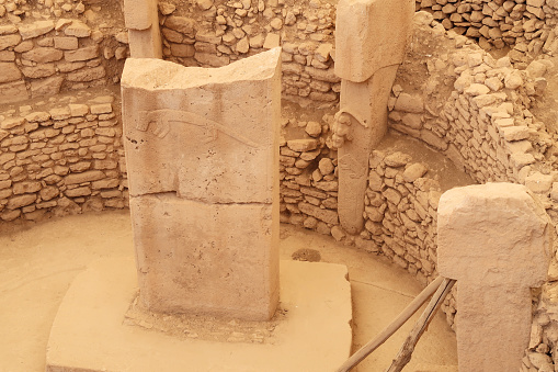 Pillar 37, central pillar showing a fox and the pillar 27 with a cat chasing a boar in Enclosure C at the neolithic archaeological site of Göbekli Tepe, Potbelly Hill, close to Sanliurfa, Turkey 2022