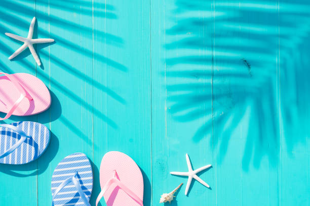 istock Composition made with flip flops on turquoise background on wooden planks with shadows of palm leaves. Concept vacation, fun, relax and leisure 2150523776
