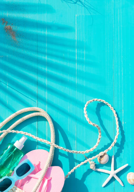 istock Vertical composition on turquoise slatted background shadow of palm leave and bag with beach accessories. Concept summer vacation leisure. 2150523838