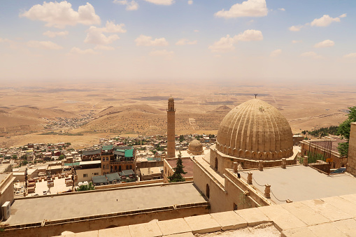 View onto the landscape of Syria from the old town of Mardin, with the Sultan Isa Medrese, Madrasa, Zinciriye Medrese and the Great, Grand Mosque, Ulu Camii in the foreground, Mardin, Turkey 2022