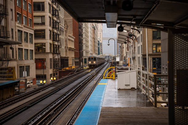 Elevated silver train running between both old and modern buildings in downtown Chicago in spring. Illinois, USA.