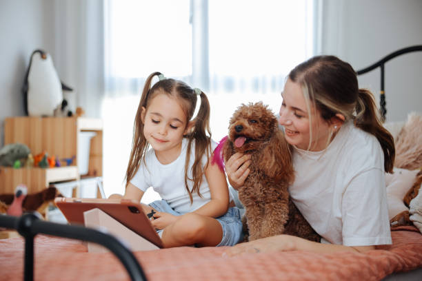 istock Mother and daughter watching their digital tablet together lying in bed 2150529465
