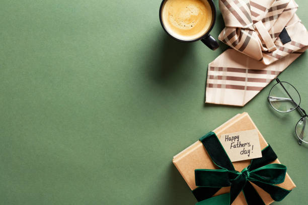 istock Happy Fathers Day concept. Flat lay composition with gift box, necktie, glasses, coffee cup on green background. 2150531922