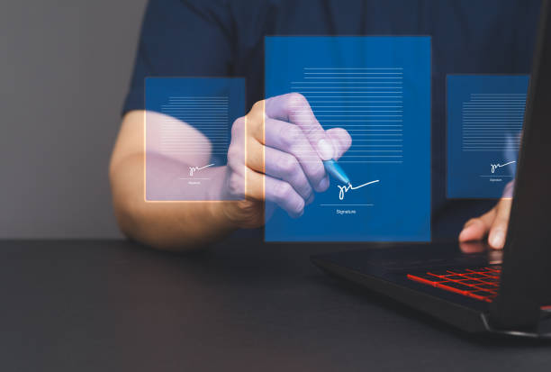 istock Signature Electronic. Businessman uses a pen to sign electronic documents on a virtual screen while sitting at a desk 2150533556