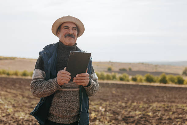 istock Fields of Time Elderly Farmer with digital tablet Reflective Portrait in Agriculture 2150537057