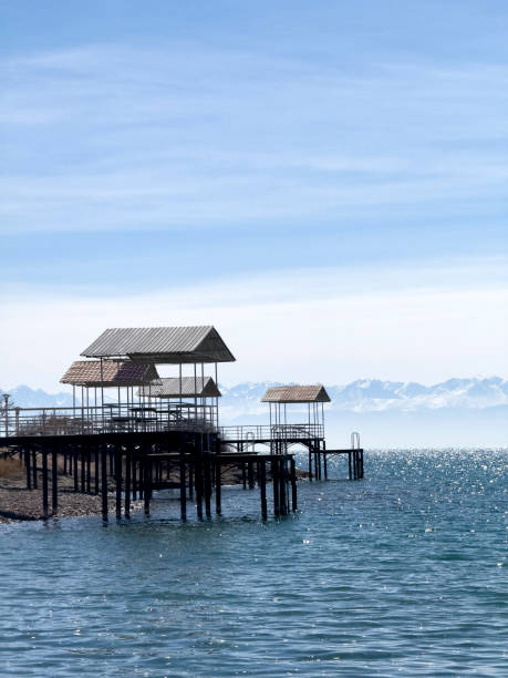 Wooden piers extend gracefully into the calm expanse of the lake, offering a picturesque scene of tranquility and leisure against the serene backdrop of nature's beauty