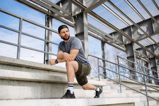 istock Morning Stretch Routine: Athletic Man Confidently Stretches in Urban Concrete Environment 2150548097