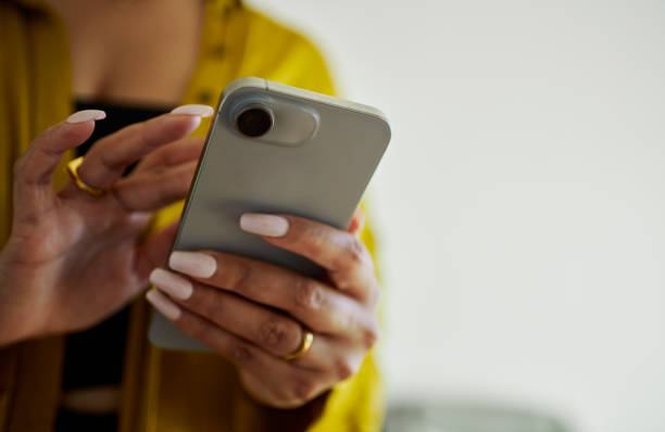 istock Close-up of Woman's Hands Texting on Mobile Phone 2150548530