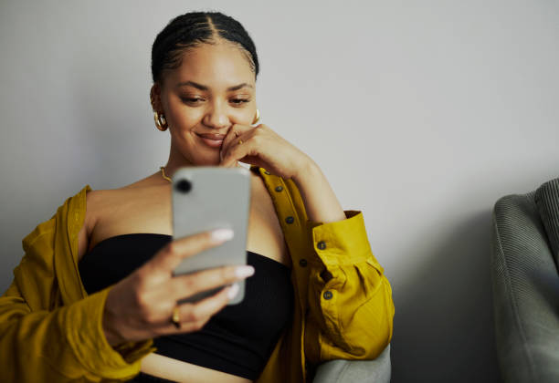 istock Happy Woman Texting on Mobile Phone at Home 2150548540