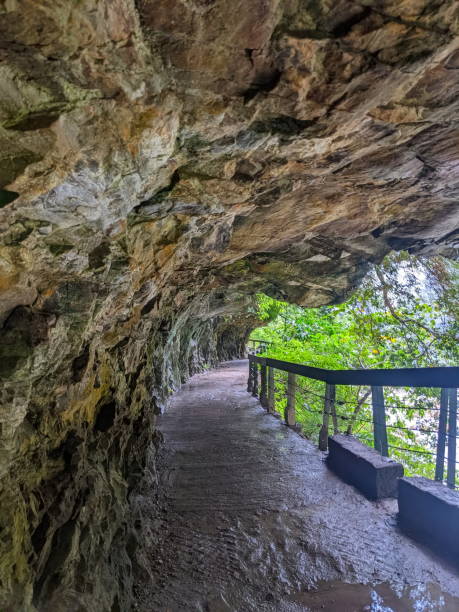 istock Wet and empty Shakadang Trail under cliffs along with trees and Liwu River in a mist during the pandemic before 403 earthquake on a rainy day 2150549250
