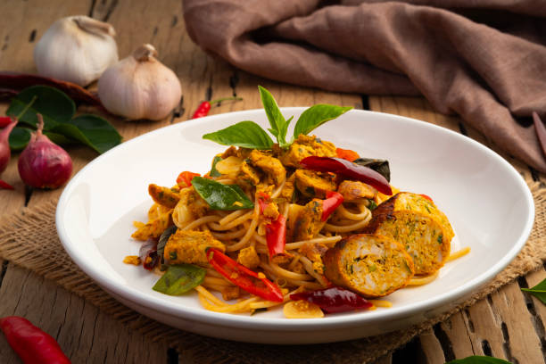 Stir fried Spaghetti with Northern Thai spicy sausage.pasta with chilli garlic and basil leaves in white plate.