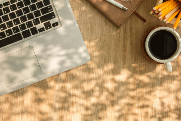 istock Modern workplace with laptop computer, coffee cup and pencils on wooden background. Top view. 2150551394