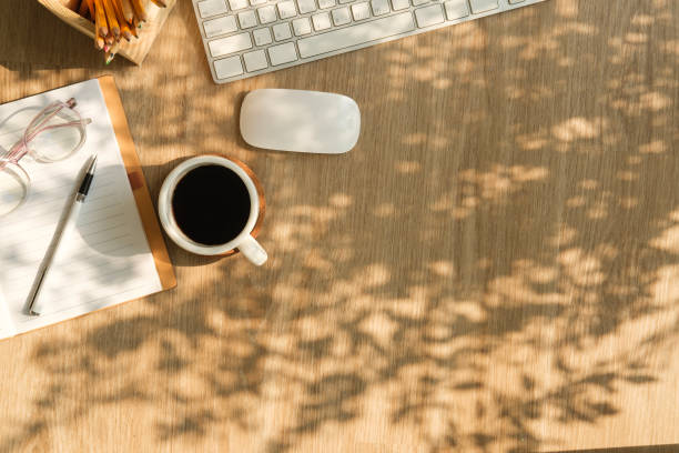 istock Simple workplace notebook, coffee cup and wireless keyboard on wooden table. Top view. 2150551406