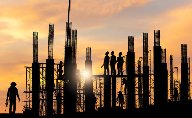 istock Silhouette of Engineer and worker checking project at building site background, construction site at sunset in evening time 2150552649