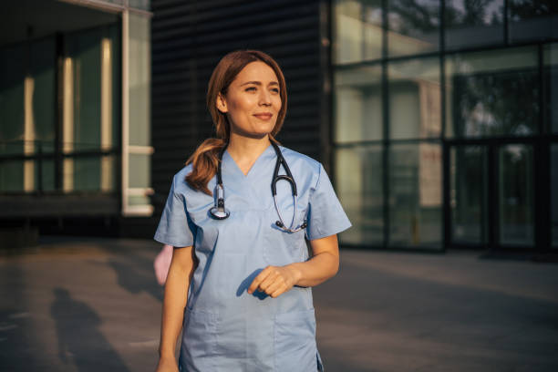 istock Hospital worker standing outside hospital while smiling and looking away. 2150555565