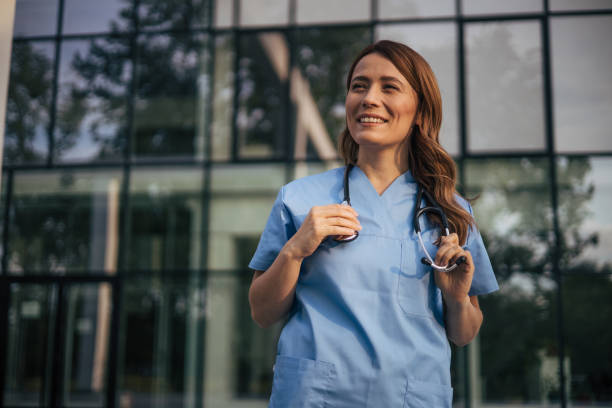 istock Hospital worker standing outside hospital while smiling and looking away. 2150555669