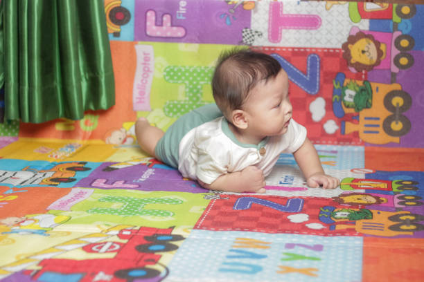 Asian baby having tummy time on mattress