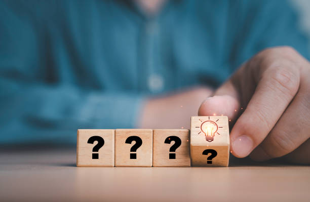 istock Hand flipping wooden block cube from question mark to glowing light bulb for Creative thinking idea and problem solving concept. 2150556049