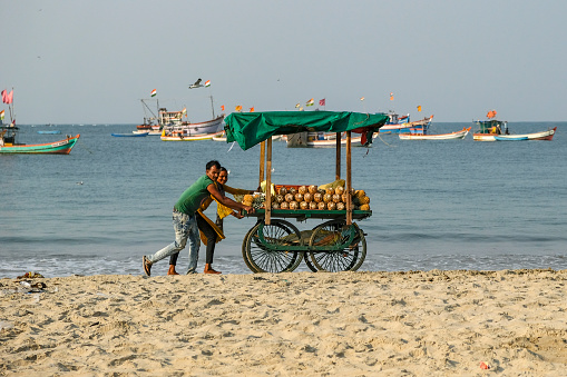 Malvan, India - February 7, 2024: A couple selling pineapples at the Malvan fish market in Maharashtra, India.