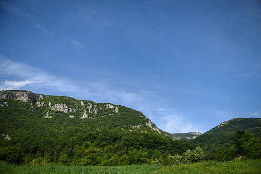 A shot of a forested hills under a deep blue sky