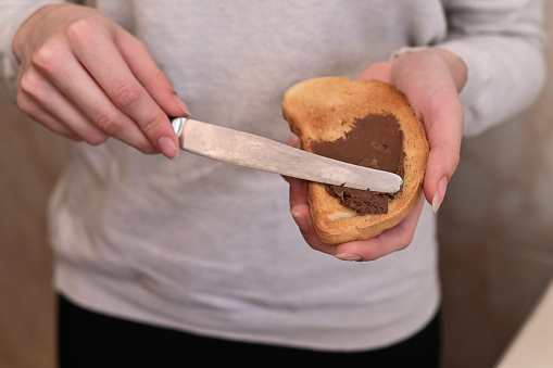 spread a slice of toasted bread with chocolate-nut cream
