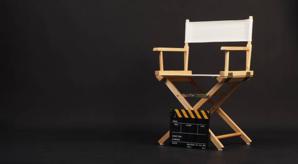 istock White director chair with yellow clapper board on black background 2150563884