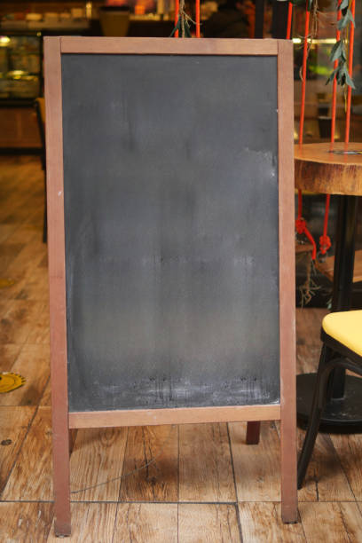 istock Empty wooden blackboard mockup standing outdoors in front of cafe 2150564031