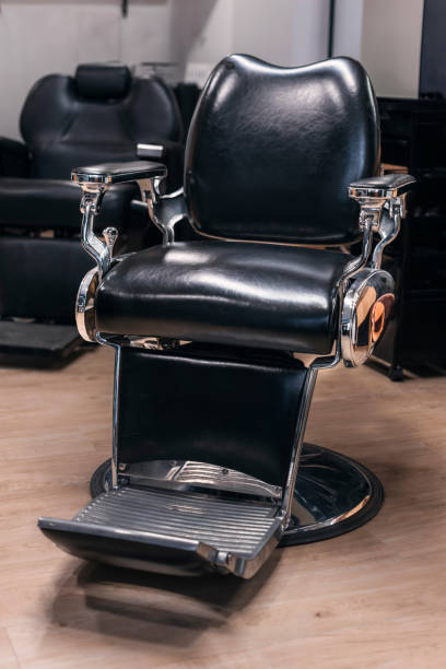 istock A black leather barber chair sits on a wooden floor. Vertical 2150566711