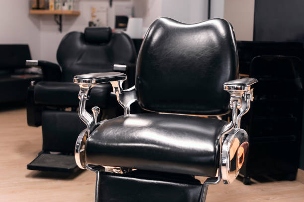 istock A black leather barber chair sits on a wooden floor. Horizontal 2150566714